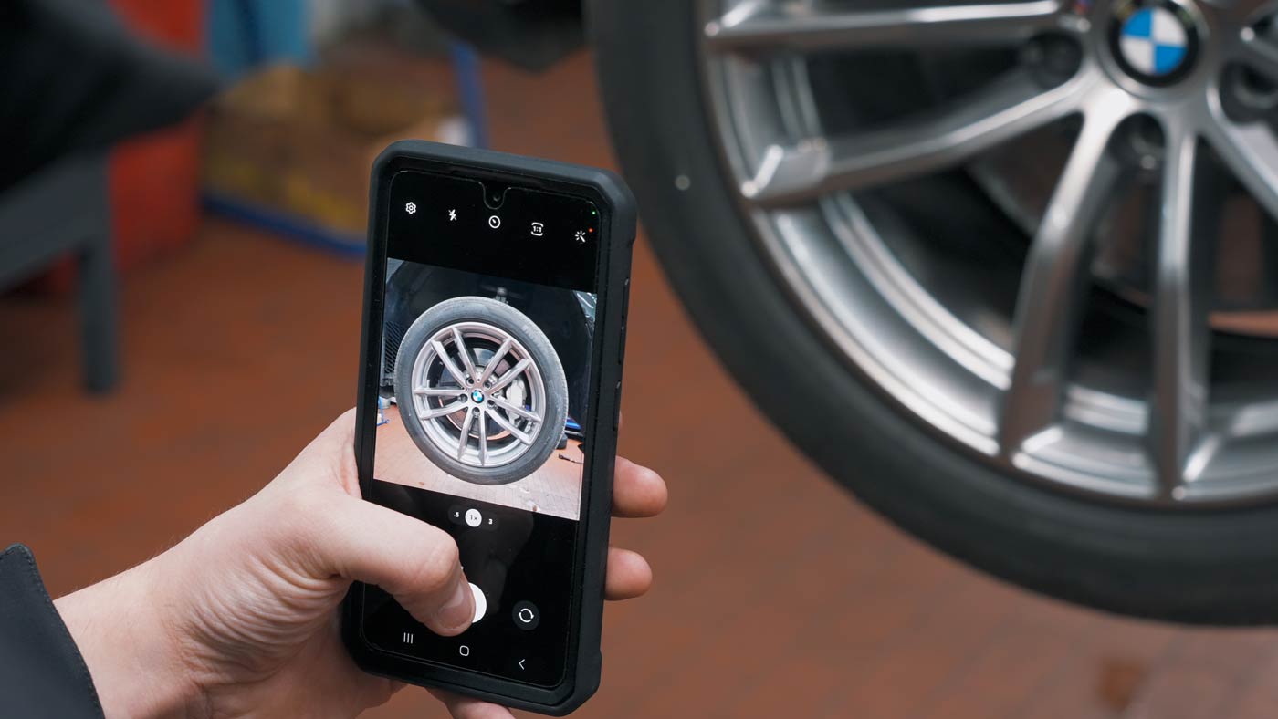 Fotografieren eines Reifens am Fahrzeug.