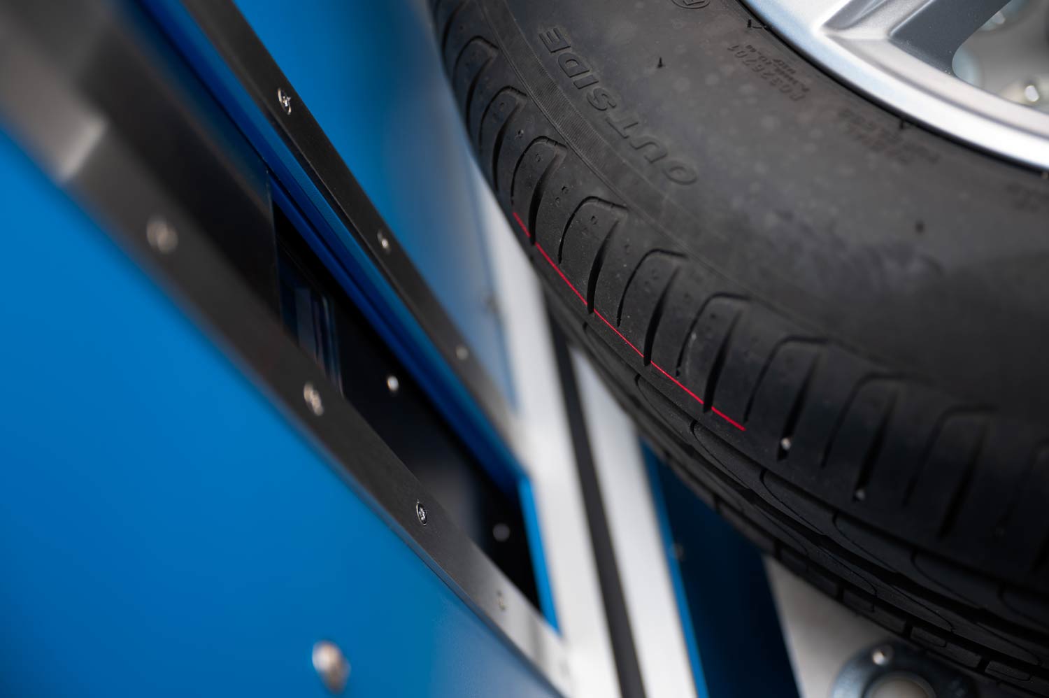 Reifen-Profilmessung mit einem Triangulationslaser. Der Laserstrahl scannt das Reifenprofil über eine Breite von 80 mm.